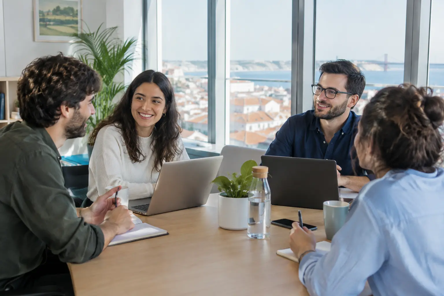 Equipa de colegas numa reunião num escritório luminoso